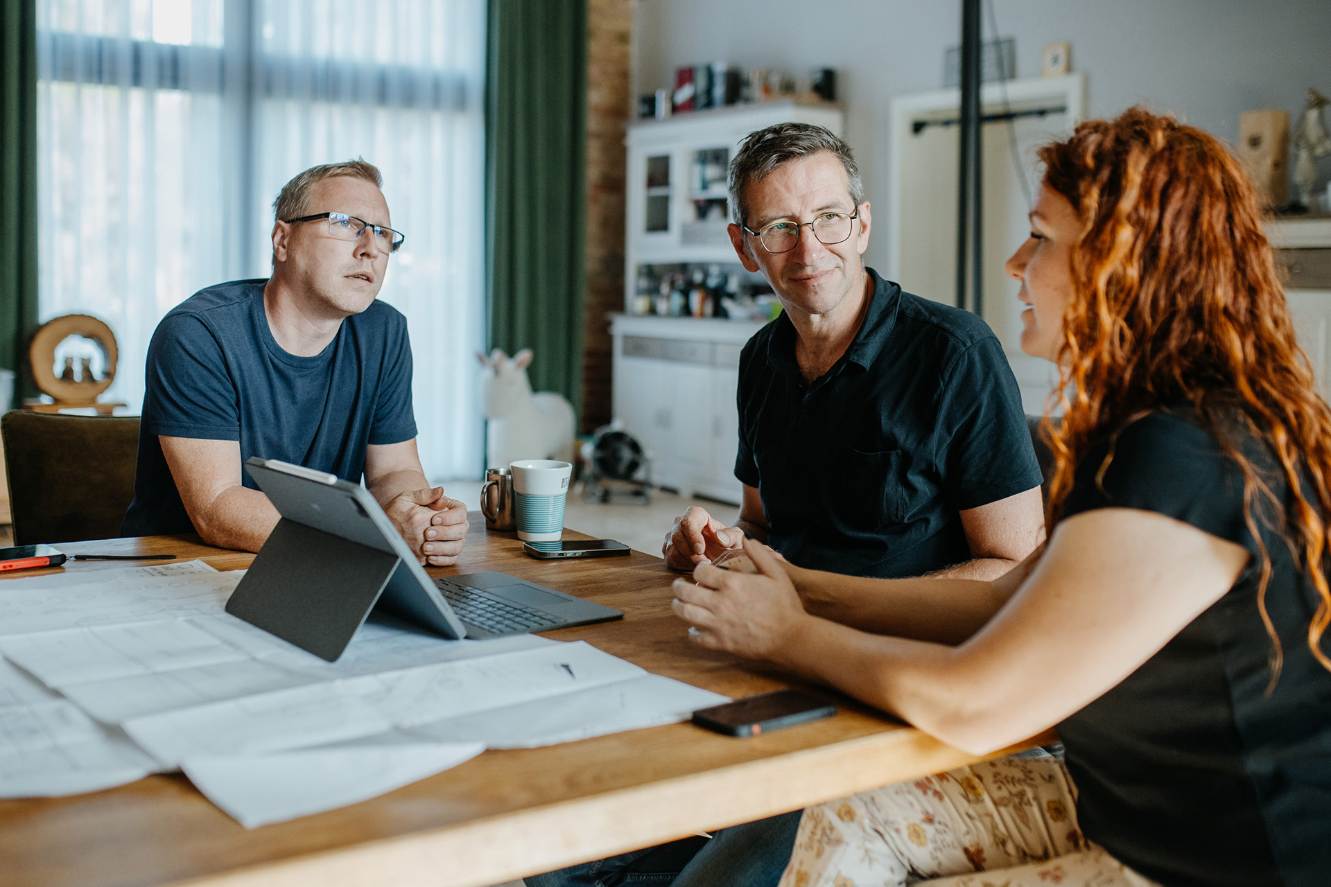Professionelles Lichtinstallations Team sitzt am Holztisch und beraet